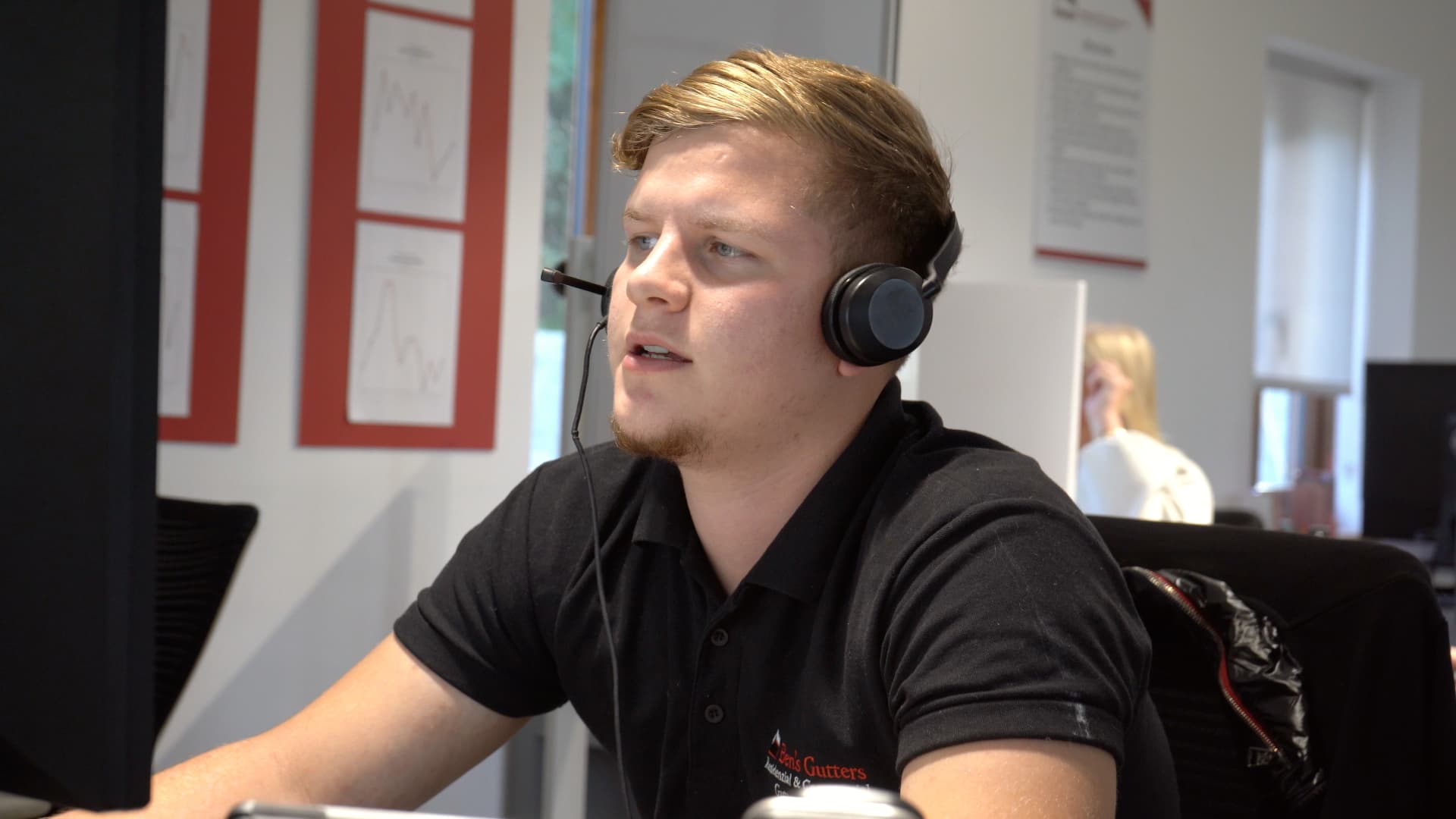 Ben's Gutters team member in branded polo wearing a headset speaking with a customer